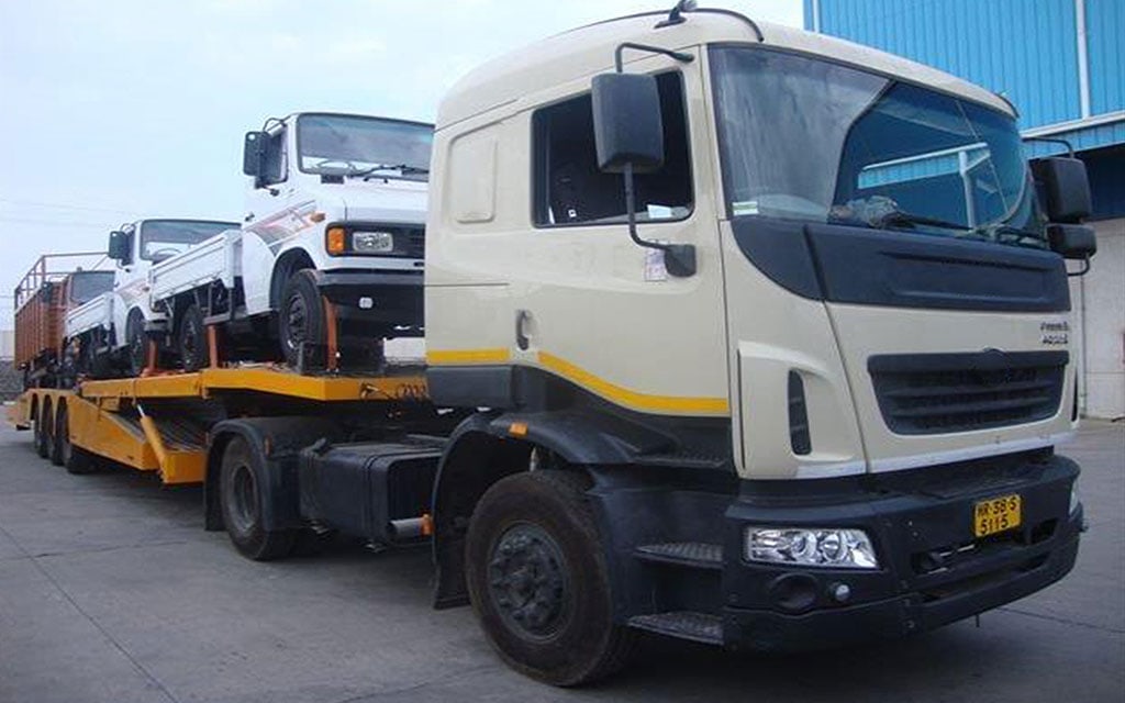 Truck pulling a car-carrier trailer loaded with vehicles
